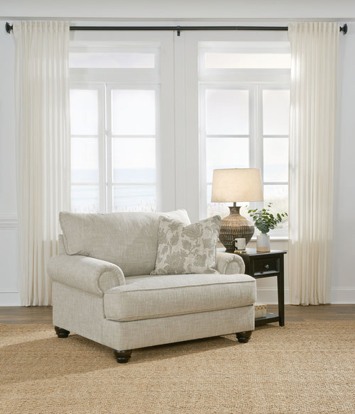 Light gray linen-style armchair with rounded arms and two patterned throw pillows
