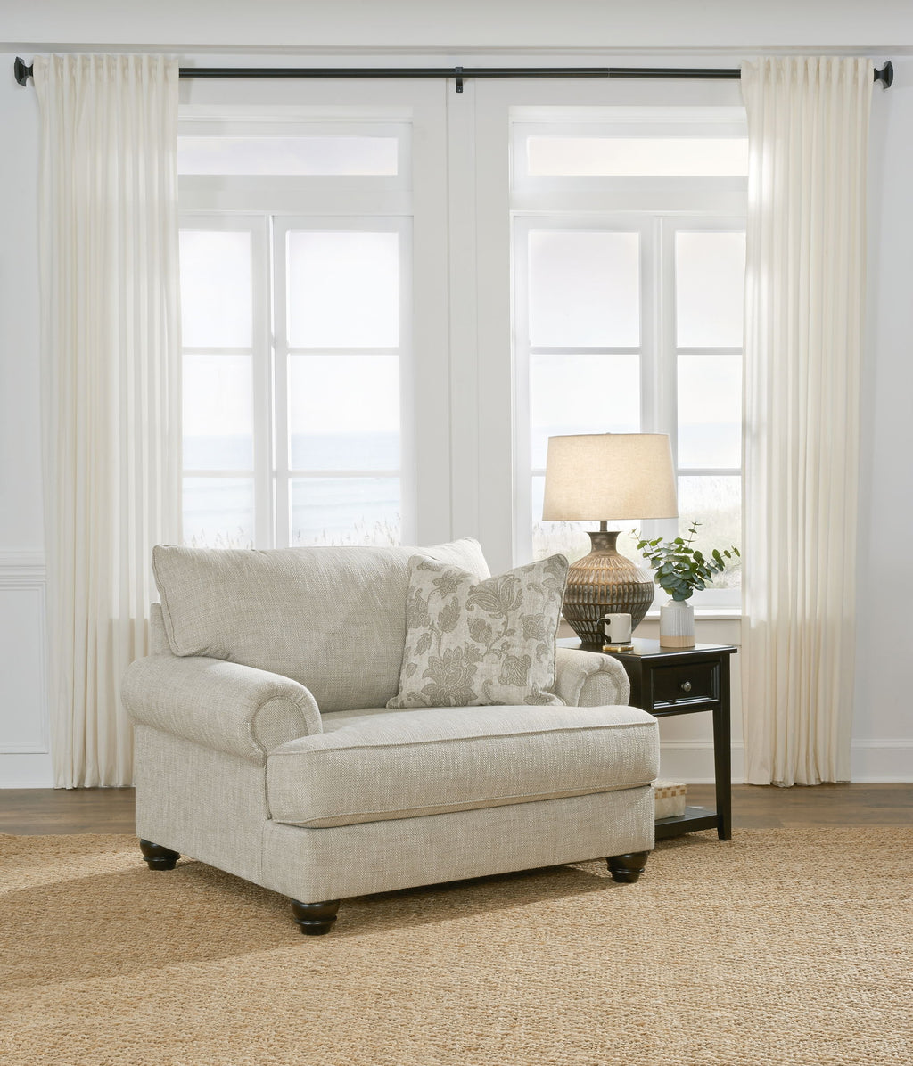 Light gray fabric sofa chair with ottoman and patterned accent pillows