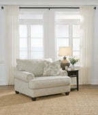 Light gray fabric sofa chair with ottoman and patterned accent pillows