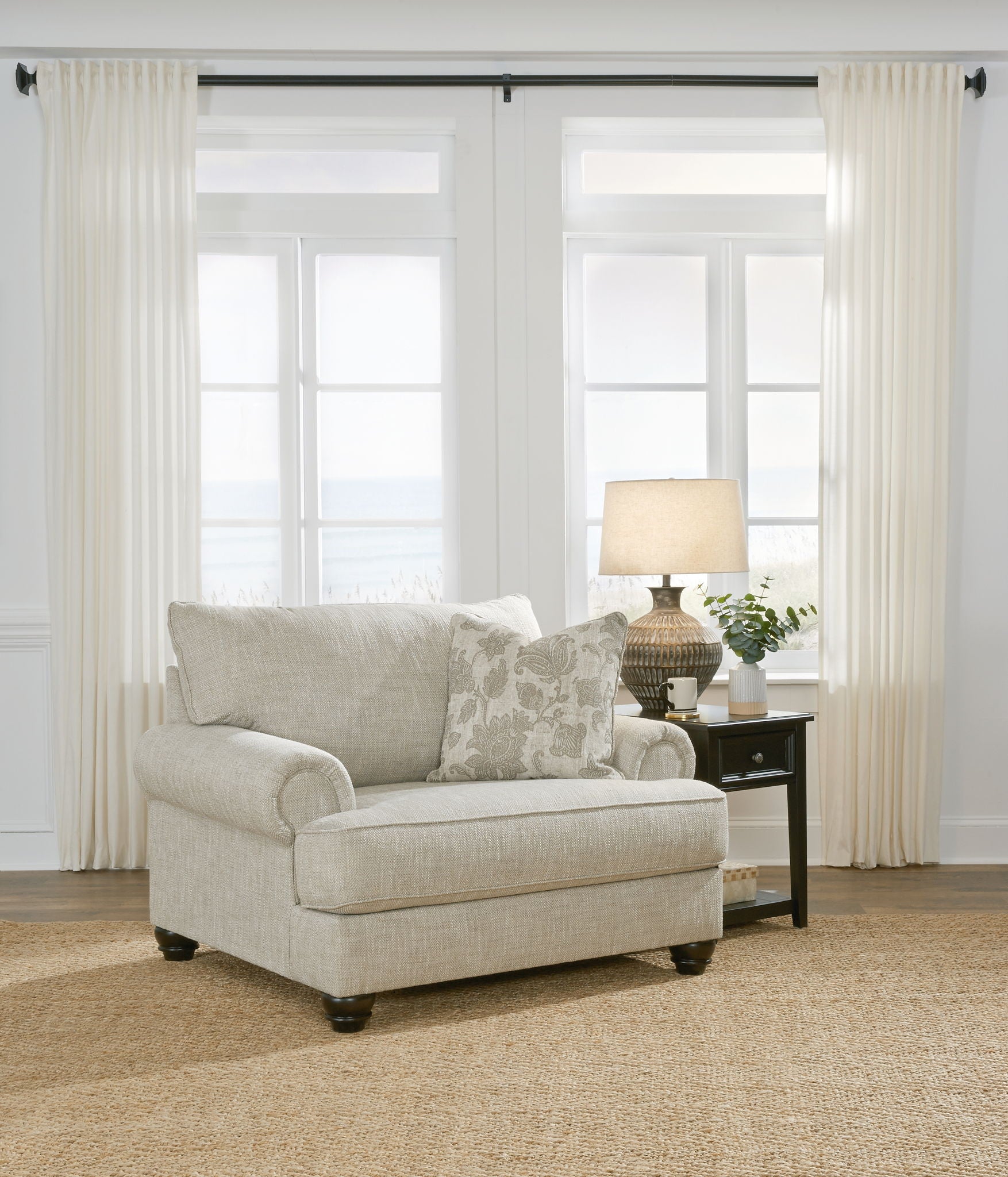 Light gray fabric sofa chair with ottoman and patterned accent pillows