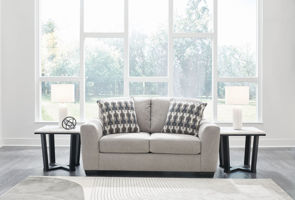 Gray flannel loveseat with two geometric-pattern throw pillows