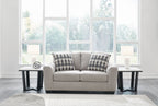 Gray flannel loveseat with two geometric-pattern throw pillows