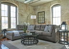 Slate gray corner sectional sofa with chaise, tufted seat cushions and patterned pillows.