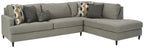 Gray sectional sofa with chaise, patterned accent pillows, and padded armrests