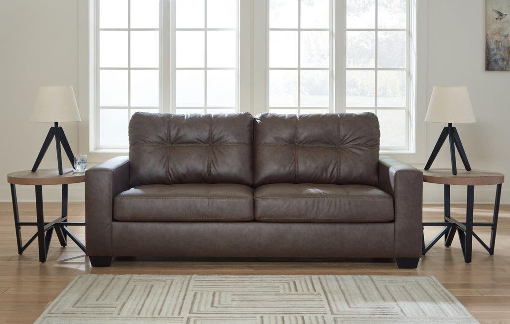 Dark gray sofa with tufted back and two seat cushions, shown with armrests