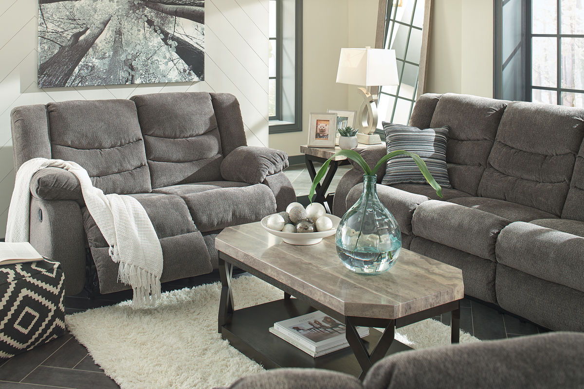 Gray sectional with two recliners and tufted back, fabric upholstery and throw blanket