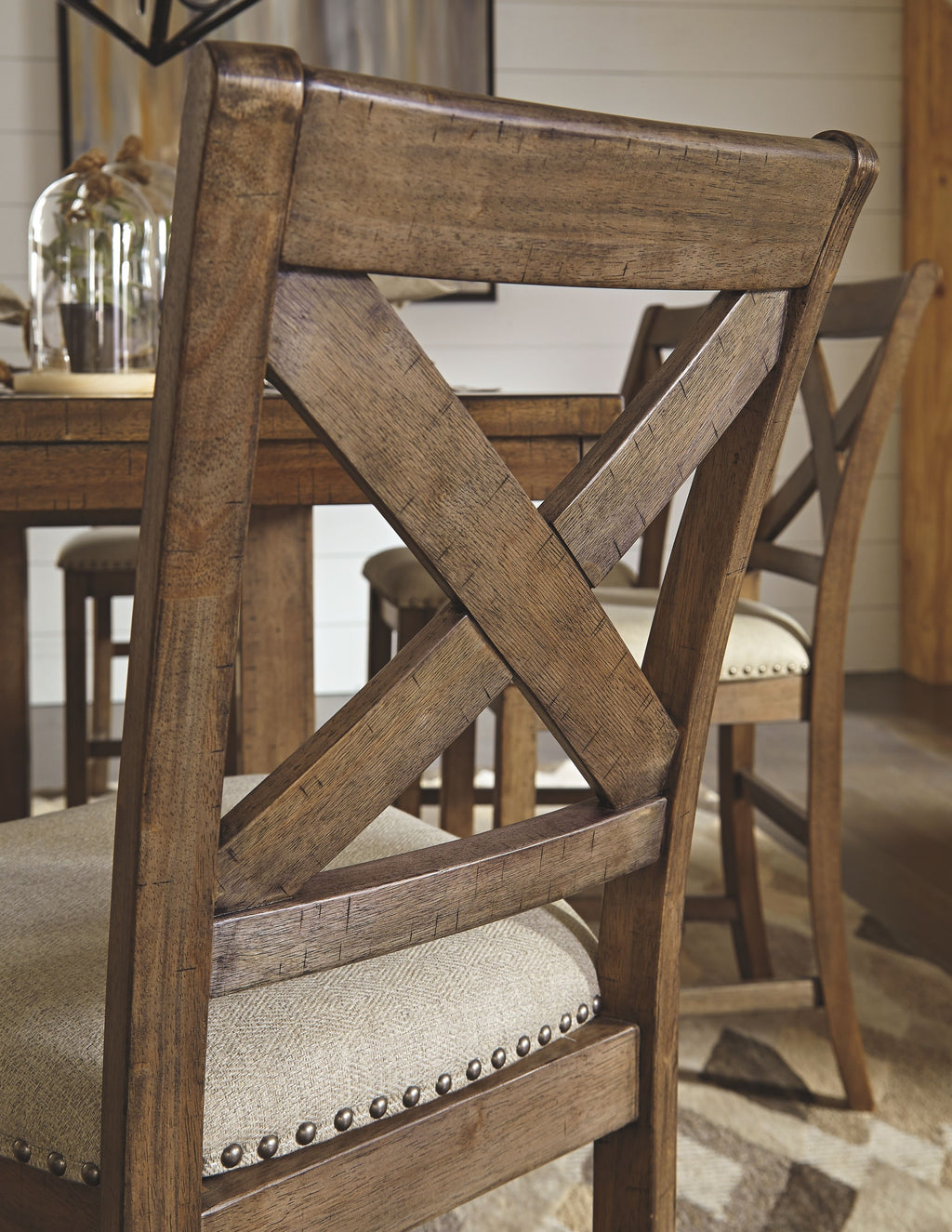 Close-up of a cross-back bar stool frame with upholstered seat