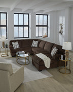 Chocolate sectional sofa with chaise seating, patterned pillows, and a throw blanket