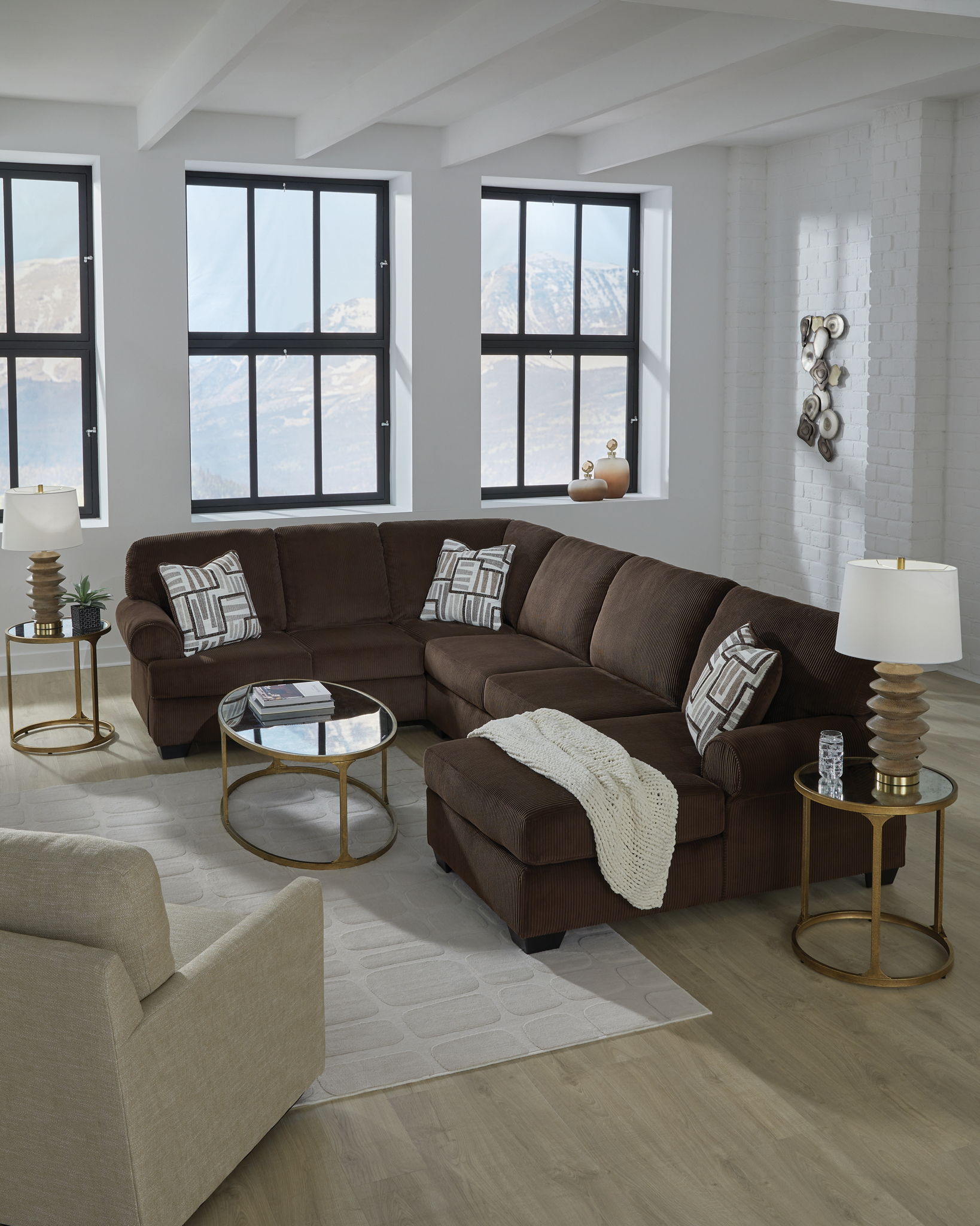 Chocolate sectional sofa with chaise seating, patterned pillows, and a throw blanket
