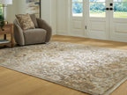 Light brown patterned area rug with distressed texture and ornate central motifs