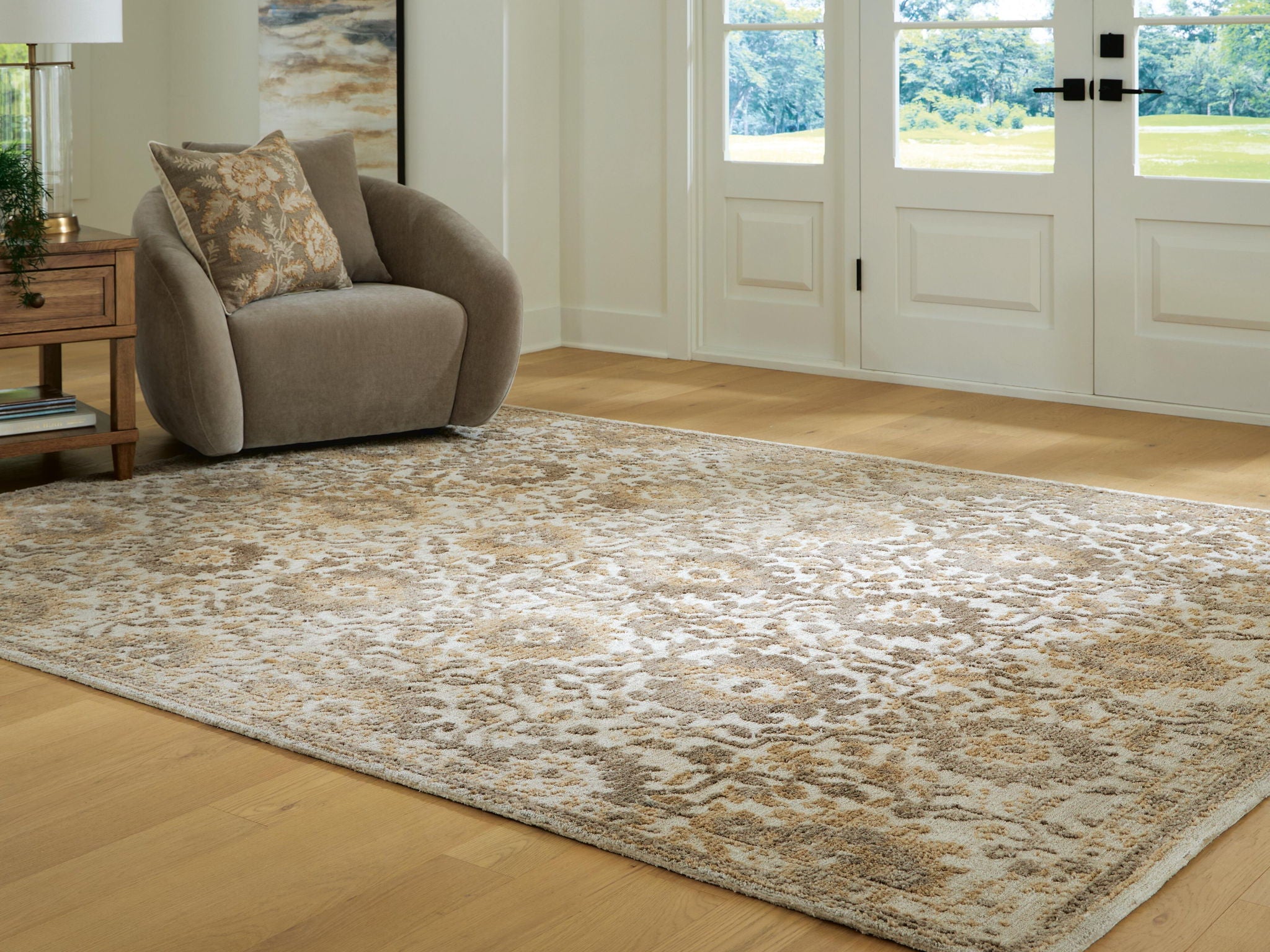 Light brown patterned area rug with distressed texture and ornate central motifs