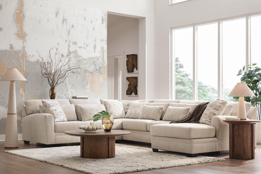 Light beige sectional sofa with chaise corner and patterned throw pillows, dark lumbar pillow