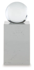 White glass sphere on white marble pedestal