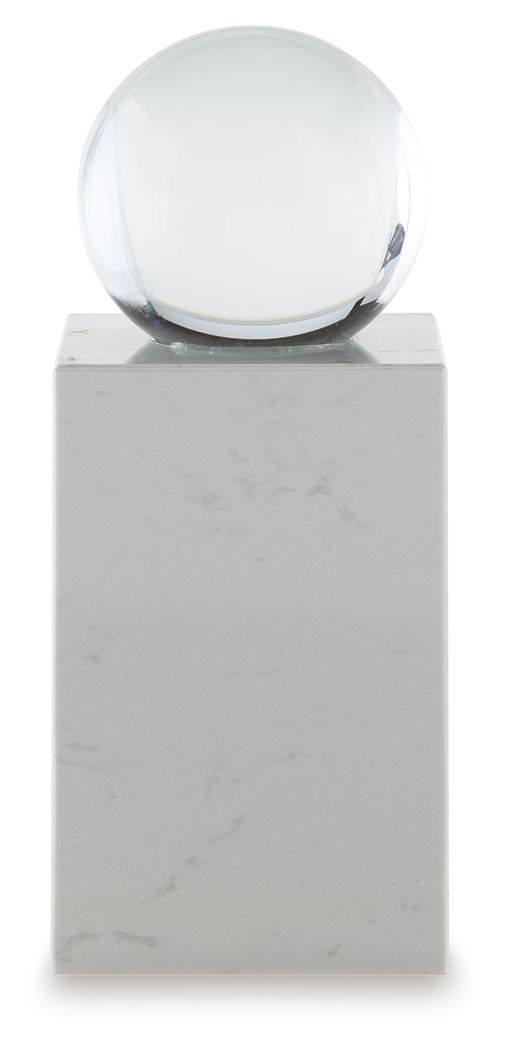 White glass sphere on white marble pedestal