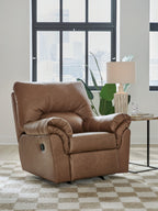 Caramel-brown upholstered rocker recliner with curved arms, tufted back, and open seating