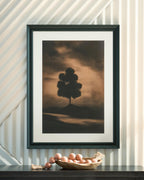 Framed wall art print with lone tree silhouette over muted brown landscape