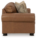 Caramel leather sofa with deep seat, rolled arms, and patterned back cushions