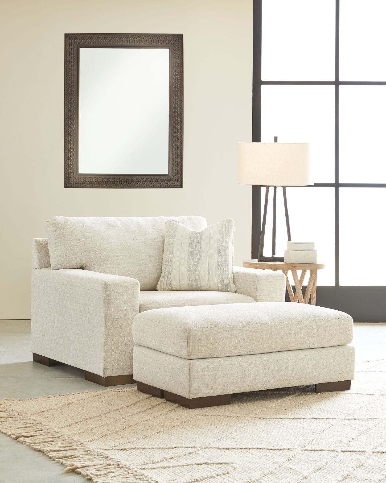 Light beige living room chair with matching ottoman and two throw pillows