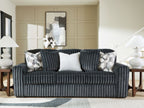 Dark gray corduroy sofa with two patterned throw pillows and a solid light center back cushion.