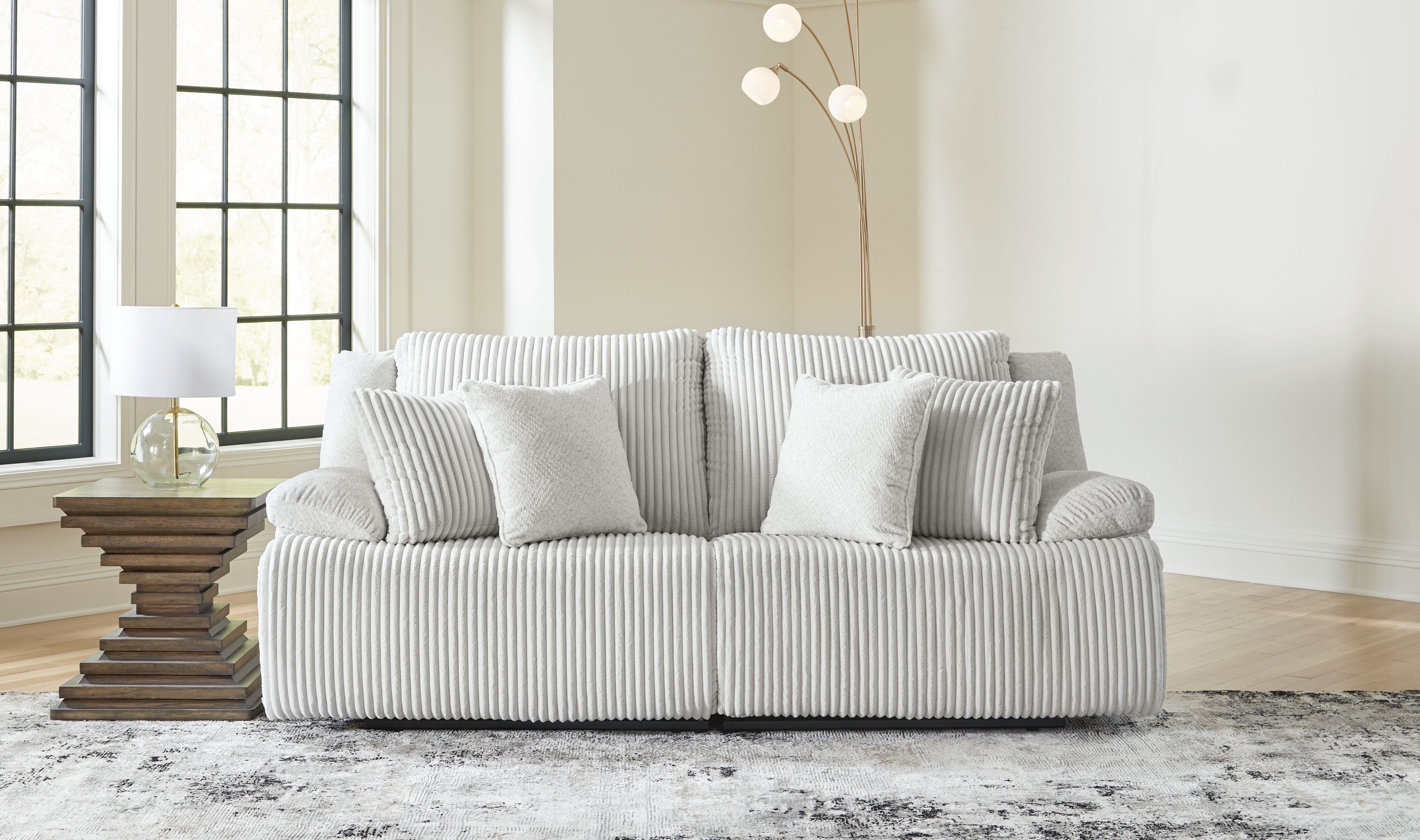 Light gray reclining sectional sofa with chaise and striped throw pillows