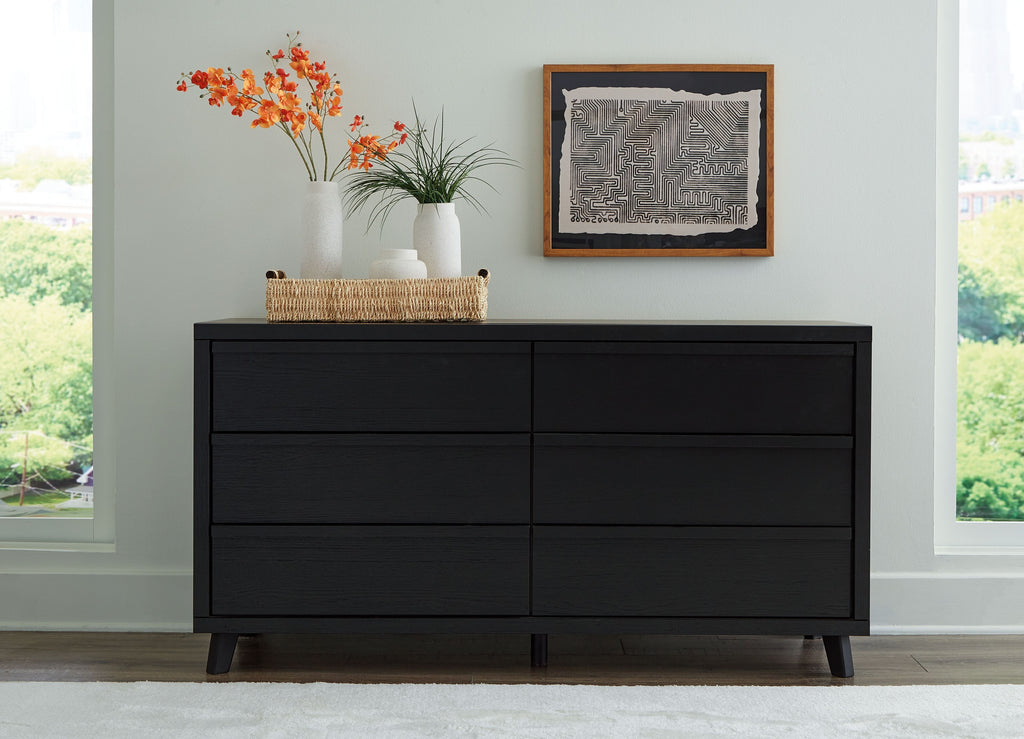 Black six-drawer dresser with wide top, six drawers, and tapered legs