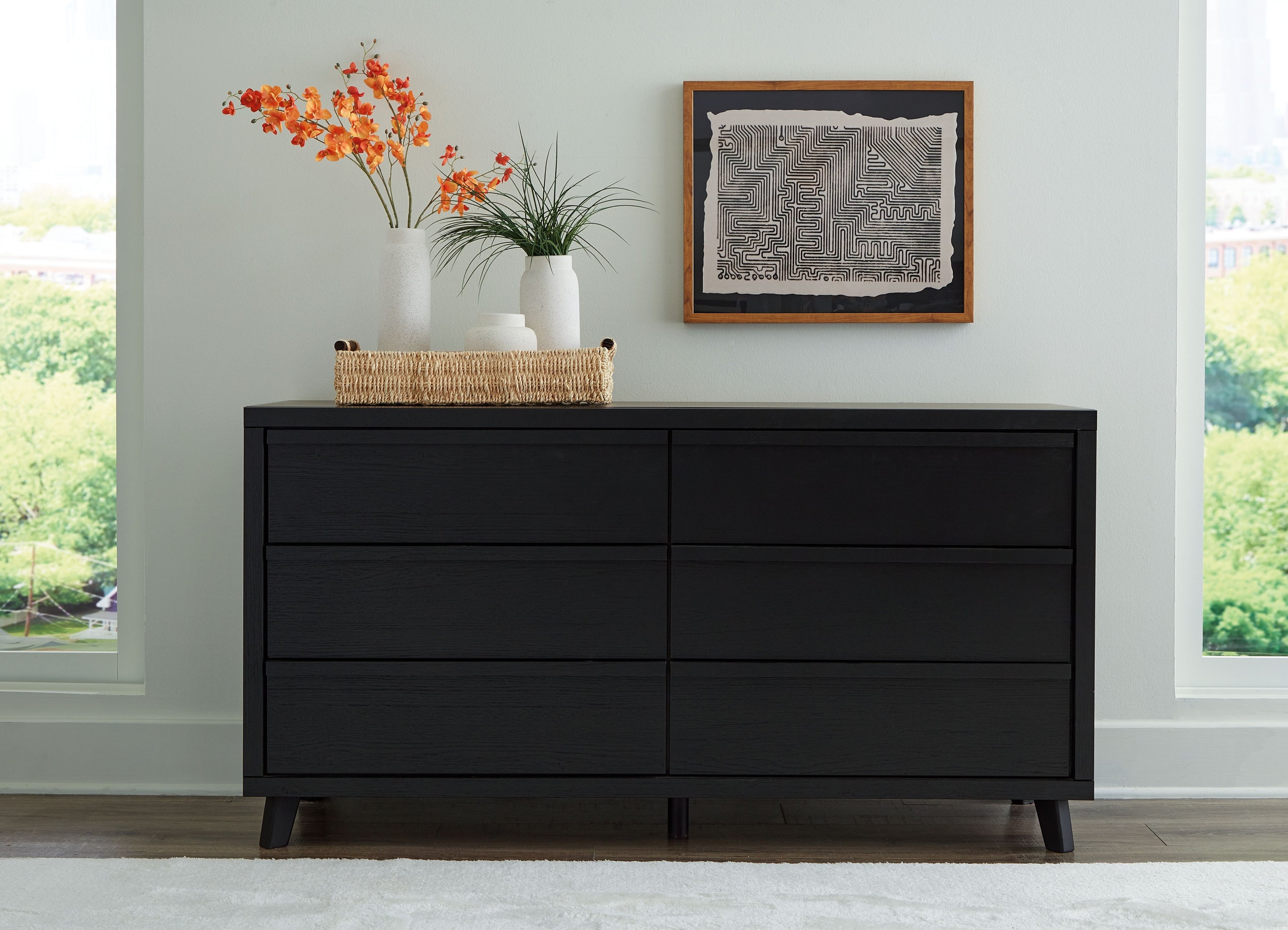 Black six-drawer dresser with wide top, six drawers, and tapered legs
