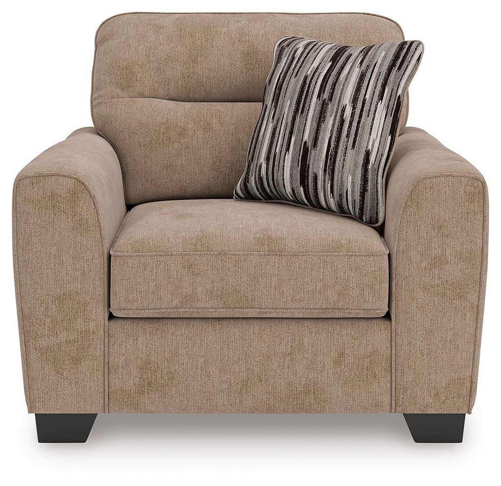 Light brown upholstered chair and a half with seat cushion and striped throw pillow
