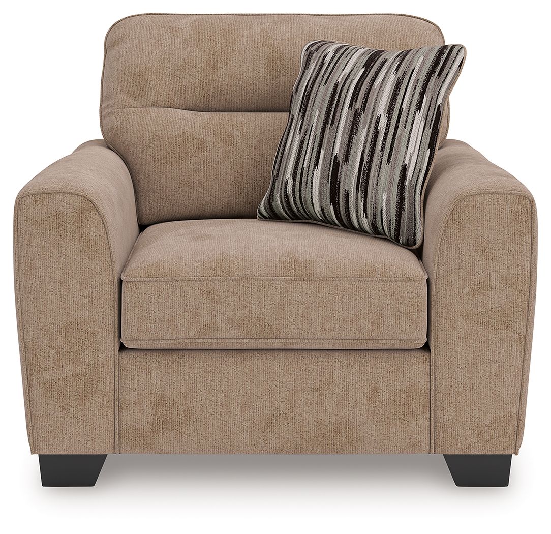 Light brown upholstered chair and a half with seat cushion and striped throw pillow