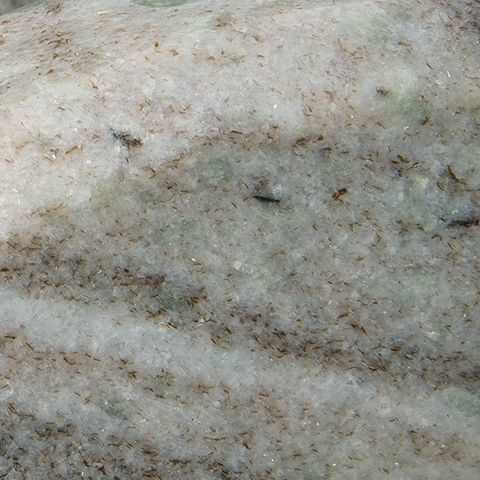 Taupe-gray stone surface with speckled texture and faint horizontal veining.