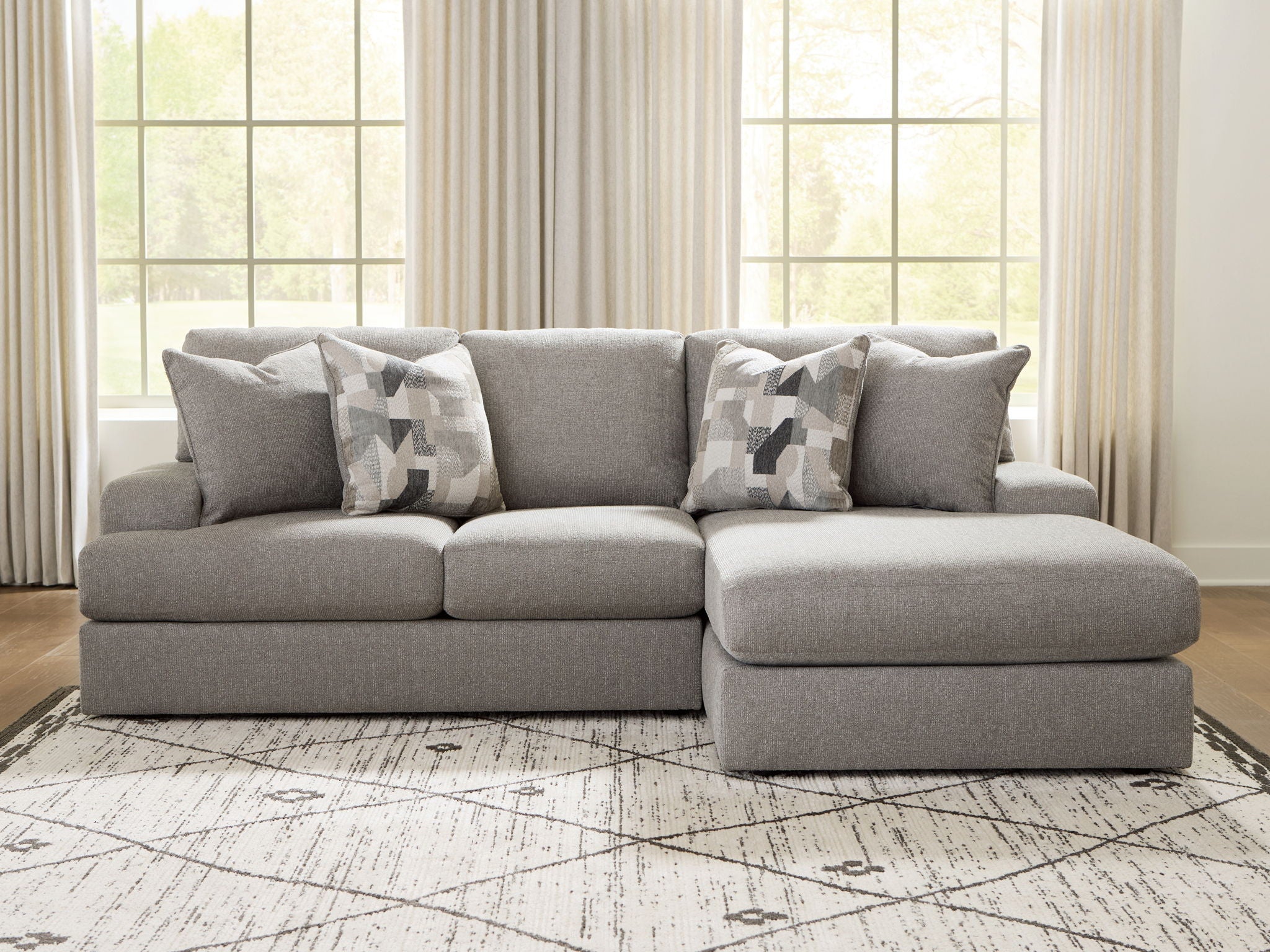 Lindon sectional sofa in smoke gray with chaise ottoman and patterned throw pillows