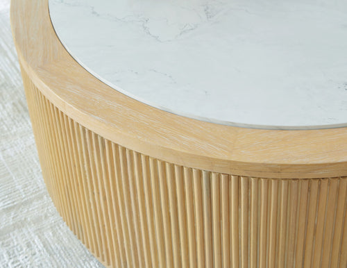 Round cocktail table with ribbed light brown wood base and white stone-look top