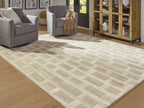 Beige geometric rug laid across hardwood, repeating blocks pattern