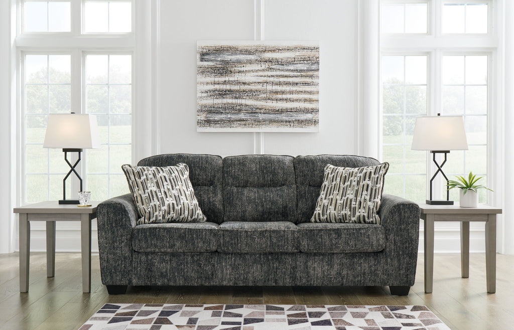 Dark gray fabric sofa with three seat cushions and patterned throw pillows