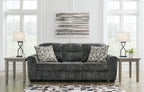 Dark gray fabric sofa with three seat cushions and patterned throw pillows
