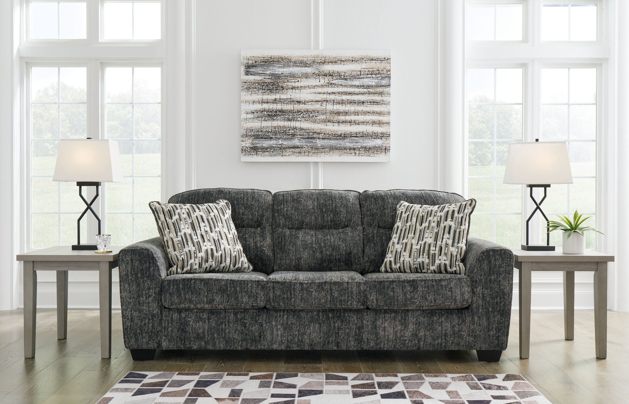 Dark gray fabric sofa with three seat cushions and patterned throw pillows