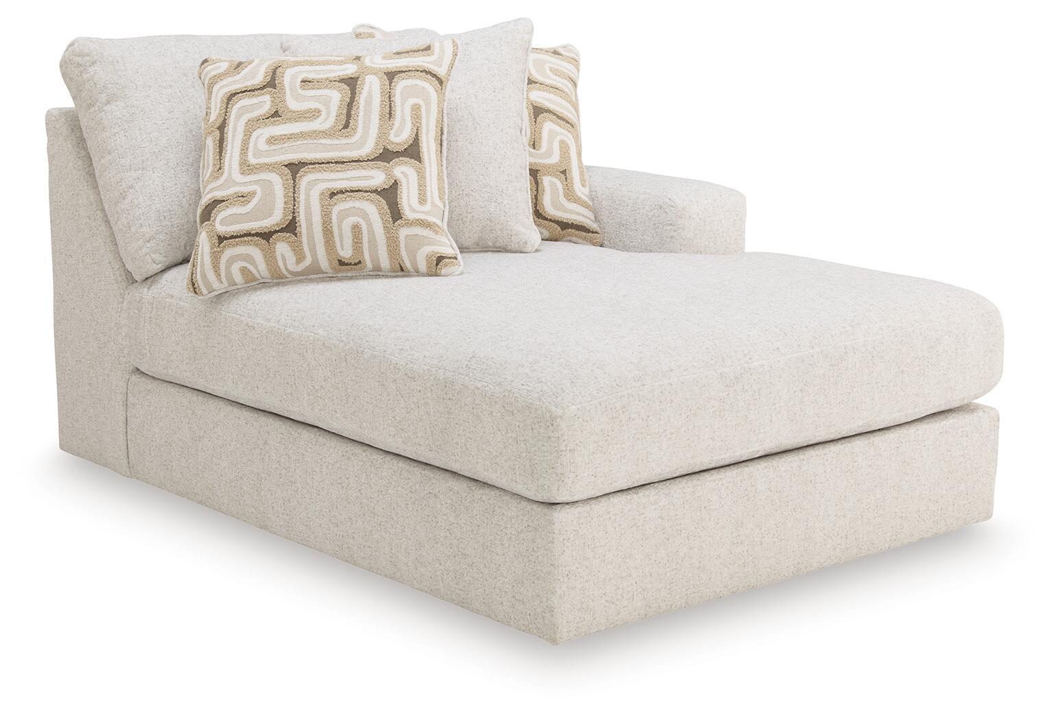 Light beige corner chaise with two patterned throw pillows and rounded arms