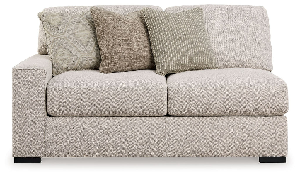 Sand-tone upholstered loveseat with two seat cushions and striped and textured throw pillows