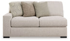 Sand-tone upholstered loveseat with two seat cushions and striped and textured throw pillows