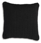 Black knitted square pillow with dense braided texture and scalloped border edge.