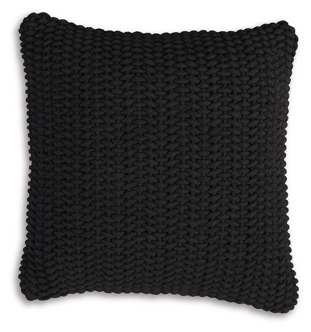 Black knitted square pillow with dense braided texture and scalloped border edge.