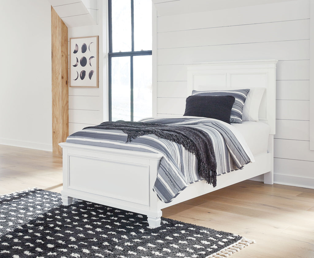 White panel bed with upholstered frame, showing black-and-white striped bedding.