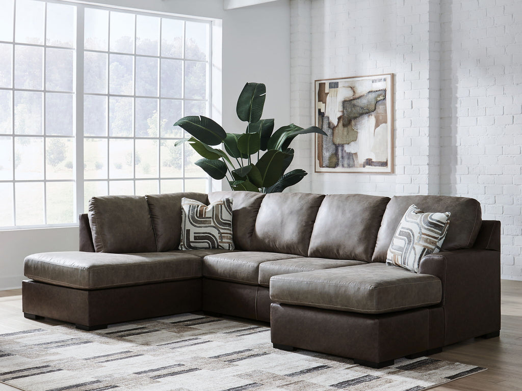 Dark fossil sectional sofa with chaise and gray throw pillows under a folded blanket