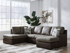 Dark fossil sectional sofa with chaise and gray throw pillows under a folded blanket