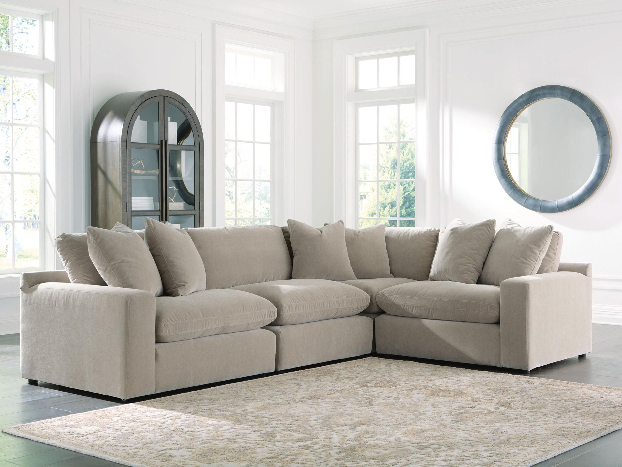 Light gray sectional sofa with deep seats, square arms, and stacked back cushions along the back.