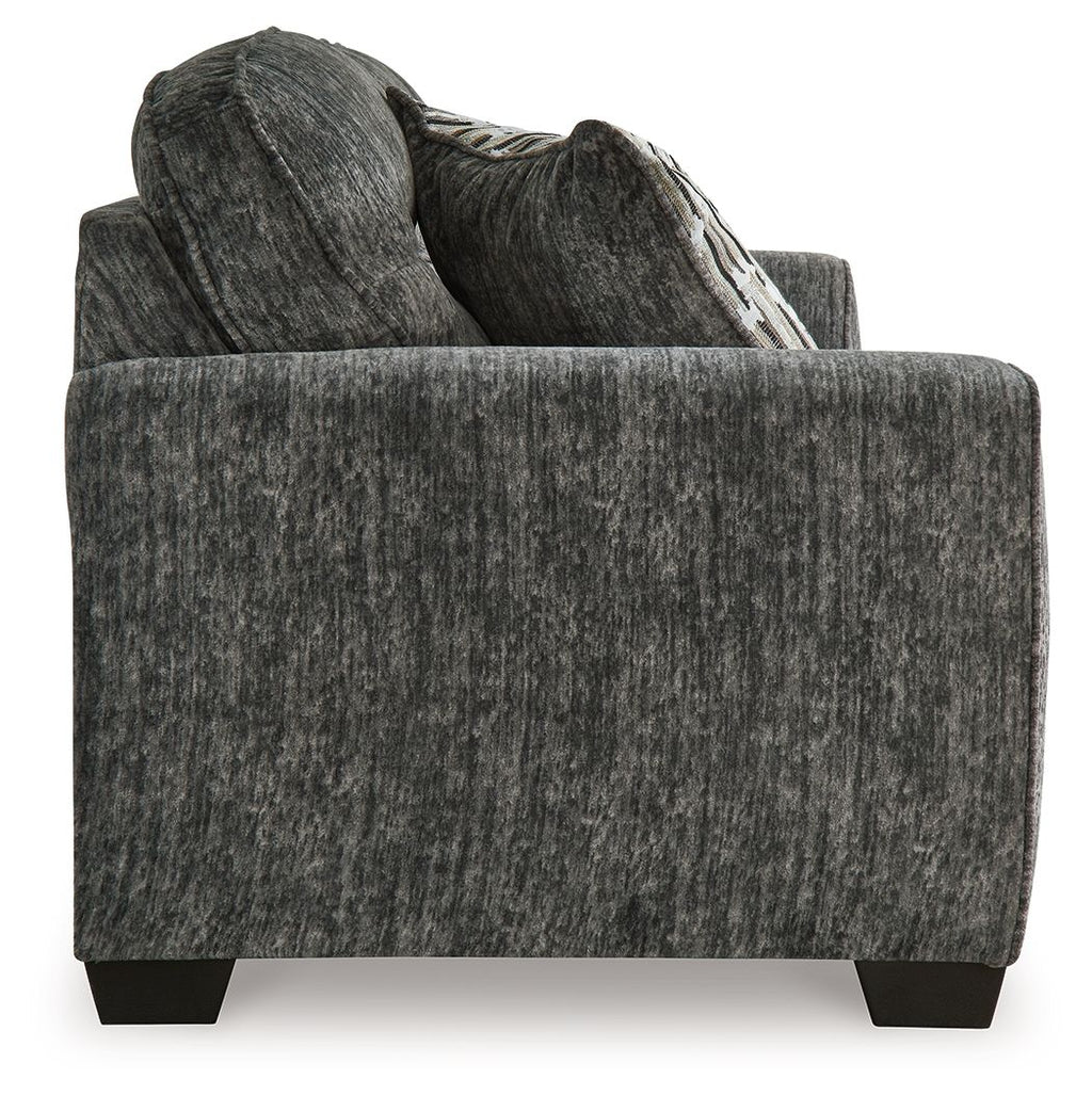Dark gray fabric sofa arm and backrest with striped throw pillow