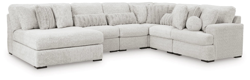 Light gray sectional sofa with curved corner seating and round accent pillows