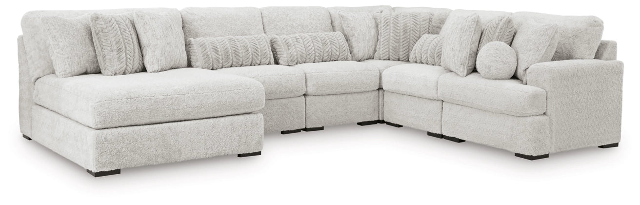 Light gray sectional sofa with curved corner seating and round accent pillows
