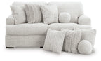 Light gray sectional sofa with round accent pillows and textured throw cushions