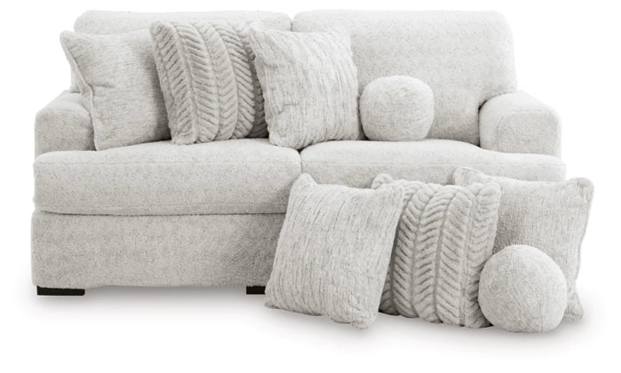 Light gray sectional sofa with round accent pillows and textured throw cushions