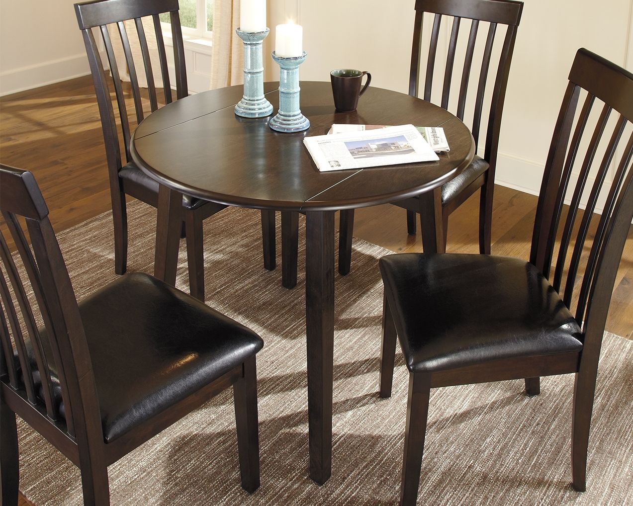 Dark brown round drop-leaf table with smooth round top and turned legs